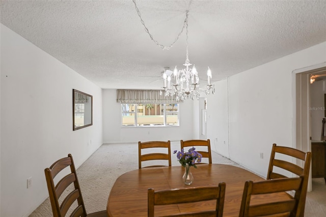 dining area with an inviting chandelier, light carpet, and a textured ceiling