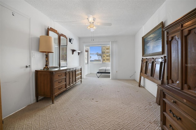 carpeted bedroom featuring a textured ceiling and ceiling fan