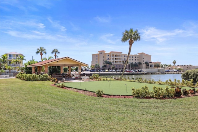 surrounding community with a lawn, a water view, and a gazebo