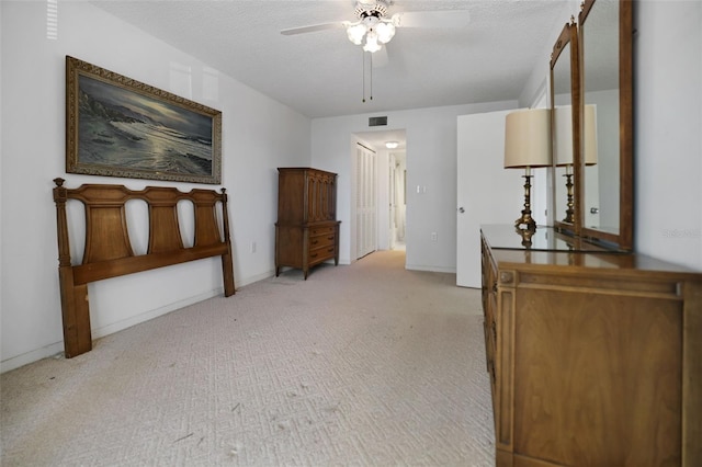 hall with a textured ceiling and light colored carpet