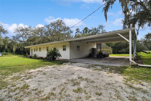 rear view of house with a lawn and a carport