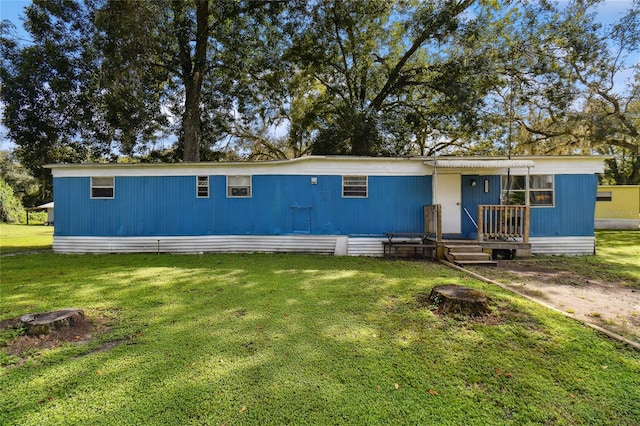 rear view of property with a lawn