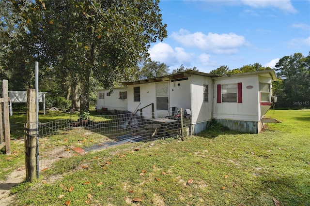 rear view of house featuring a lawn