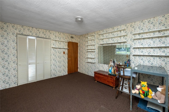 miscellaneous room featuring a textured ceiling and carpet flooring