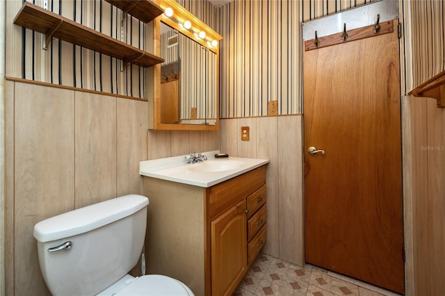 bathroom featuring toilet, vanity with extensive cabinet space, and tile flooring