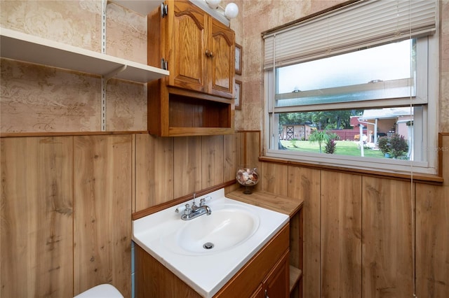 bathroom featuring a wealth of natural light, wood walls, and oversized vanity