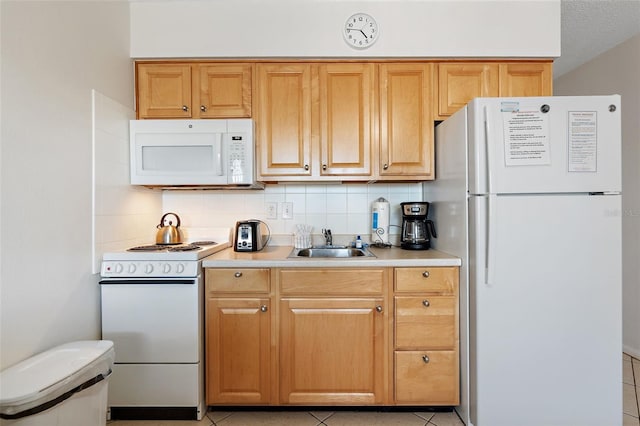 kitchen with light tile flooring, tasteful backsplash, white appliances, and sink