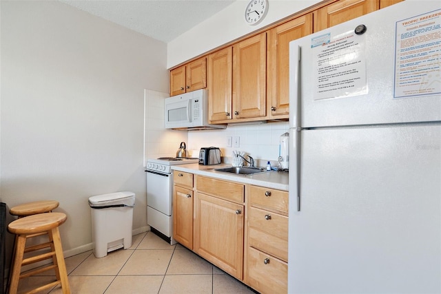 kitchen with backsplash, light tile floors, white appliances, and sink