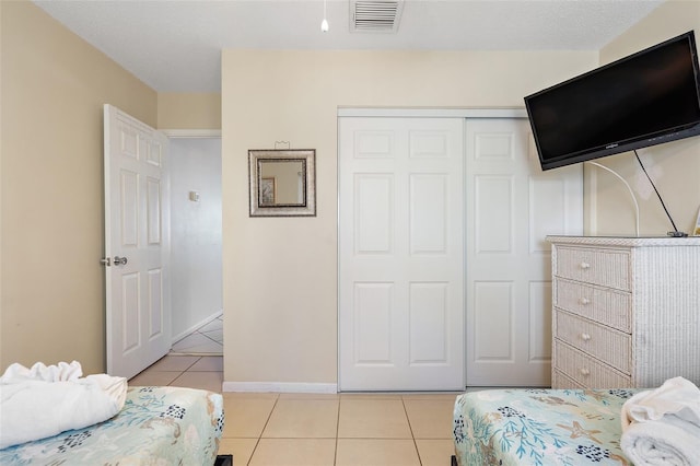 bedroom featuring a closet and light tile floors