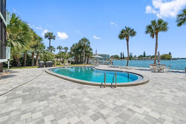 view of pool with a patio and a water view