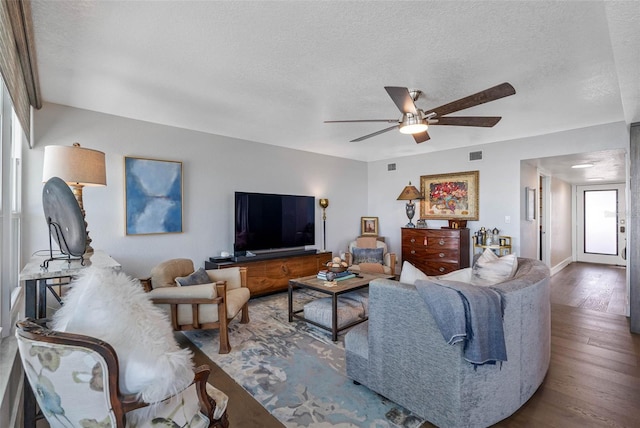 living room featuring a textured ceiling, hardwood / wood-style flooring, and ceiling fan