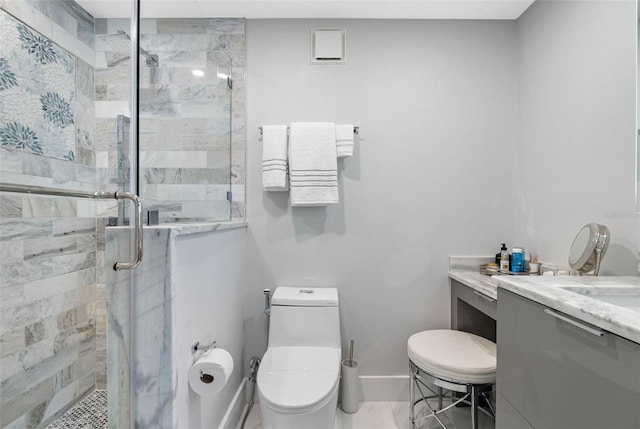 bathroom featuring vanity, a shower with shower door, and toilet