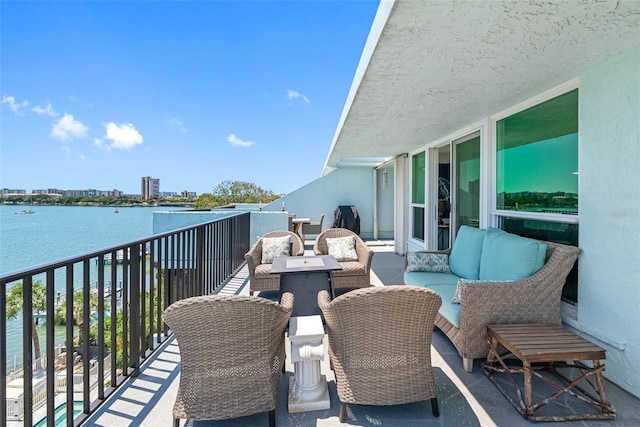 balcony with an outdoor living space and a water view