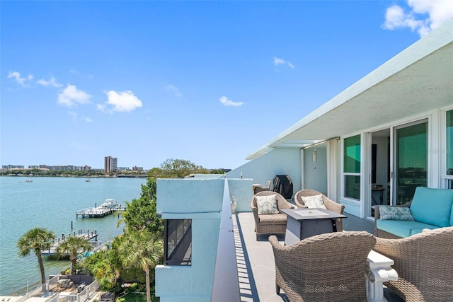 view of patio featuring a balcony, an outdoor hangout area, and a water view