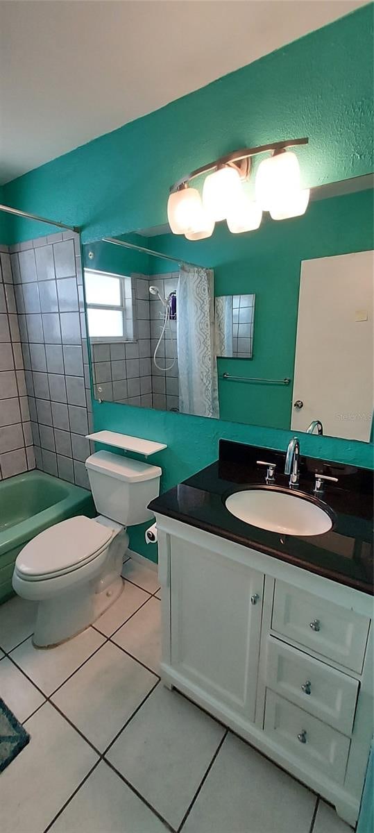 full bathroom with vanity, tile flooring, toilet, and tiled shower / bath