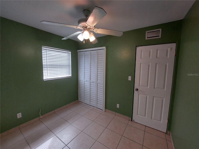 unfurnished bedroom with a closet, ceiling fan, and light tile floors