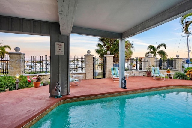 pool at dusk with a patio area