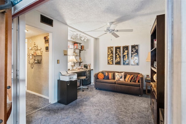 carpeted living room with ceiling fan, rail lighting, and a textured ceiling