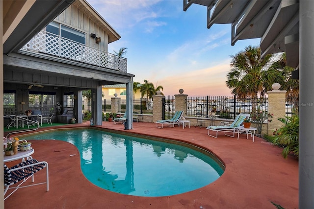 pool at dusk featuring a patio