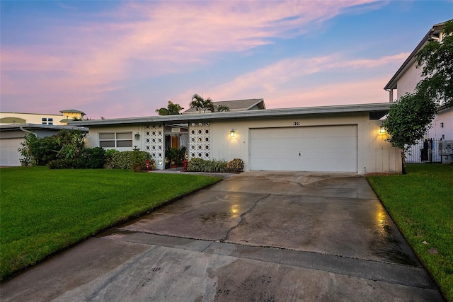 single story home with a garage and a lawn