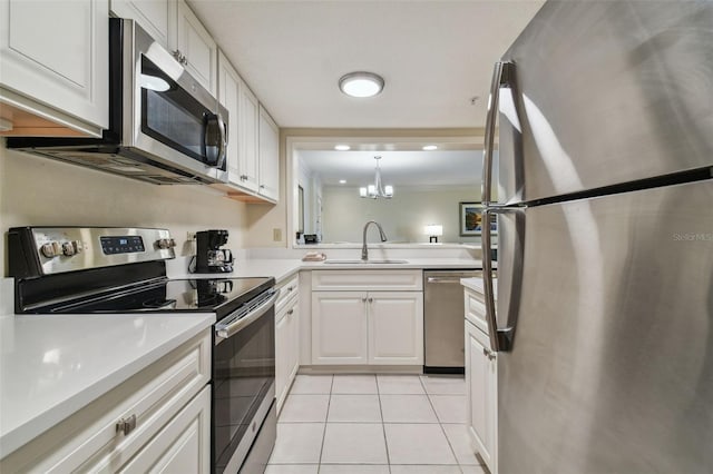 kitchen with light tile floors, a notable chandelier, appliances with stainless steel finishes, white cabinets, and sink