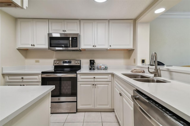 kitchen featuring light tile floors, appliances with stainless steel finishes, white cabinetry, and sink