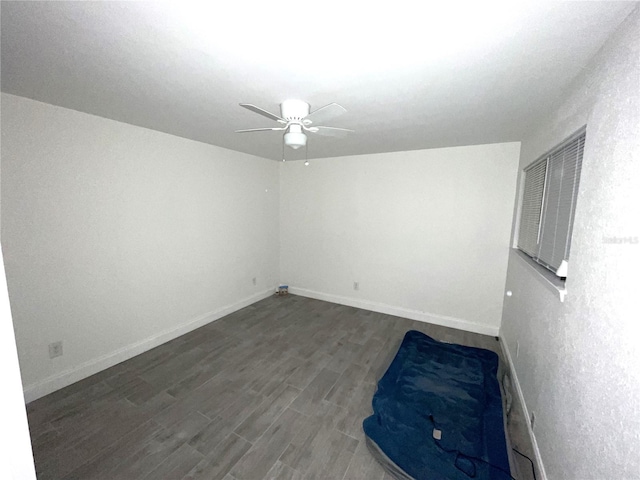 empty room with ceiling fan and dark hardwood / wood-style flooring