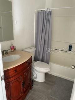 full bathroom featuring shower / tub combo, vanity, and toilet