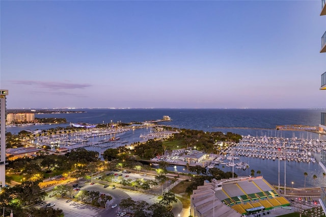 aerial view at dusk featuring a water view