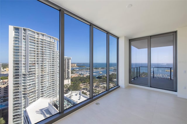 unfurnished room with light tile floors and floor to ceiling windows