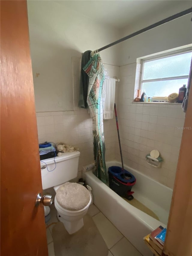 bathroom featuring tile walls, toilet, shower / bath combo, and tile floors