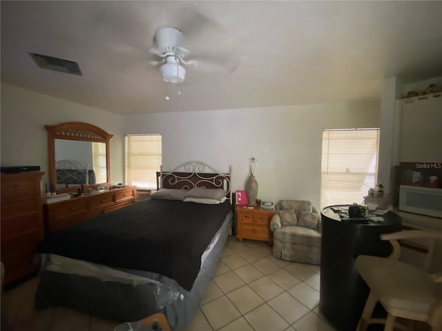 bedroom with ceiling fan and light tile flooring