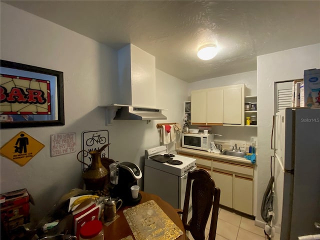 kitchen with white appliances, sink, light tile floors, white cabinets, and extractor fan