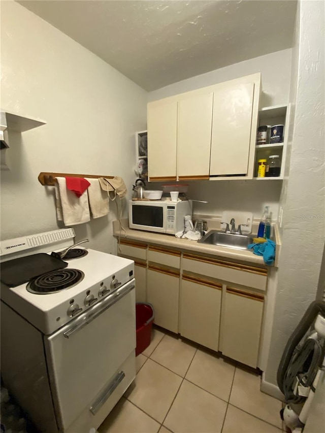 kitchen featuring sink, white appliances, light tile floors, and white cabinets