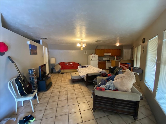 bedroom with white refrigerator, a notable chandelier, and light tile floors