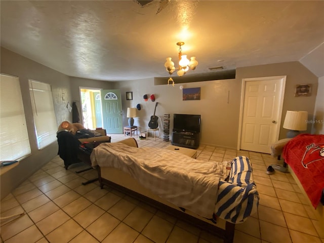 bedroom with an inviting chandelier and light tile floors