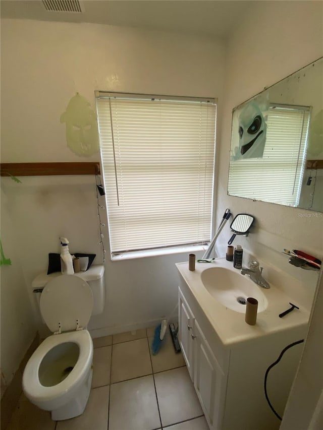 bathroom with toilet, tile flooring, and vanity