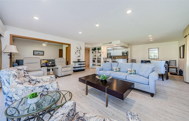 living room with light hardwood / wood-style floors and ceiling fan