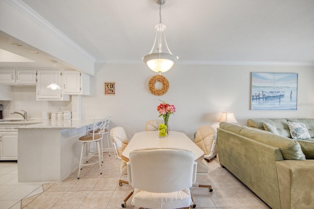 dining area featuring crown molding, sink, and light tile patterned floors