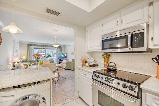 kitchen featuring light tile patterned floors, white cabinetry, hanging light fixtures, stainless steel appliances, and washer / clothes dryer