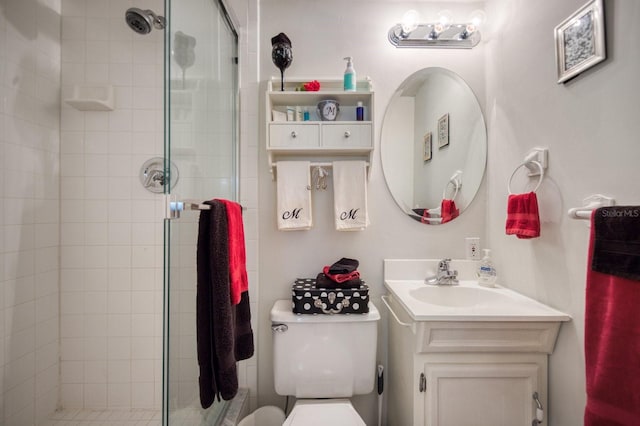 bathroom with vanity, toilet, and a shower with shower door