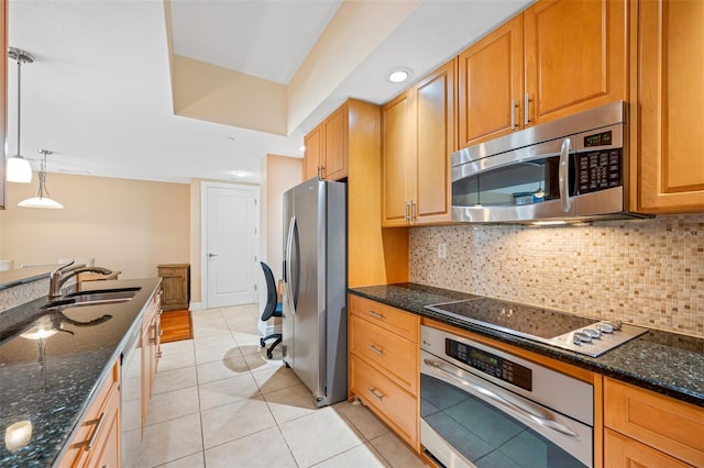 kitchen with sink, light tile floors, stainless steel appliances, tasteful backsplash, and decorative light fixtures