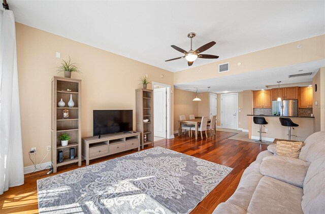 living room featuring ceiling fan and wood-type flooring