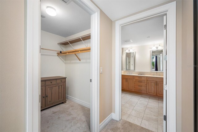 walk in closet featuring light tile floors and sink