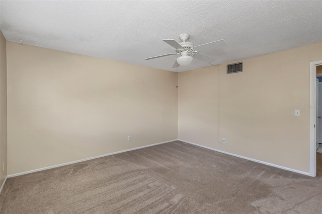 carpeted empty room with ceiling fan and a textured ceiling