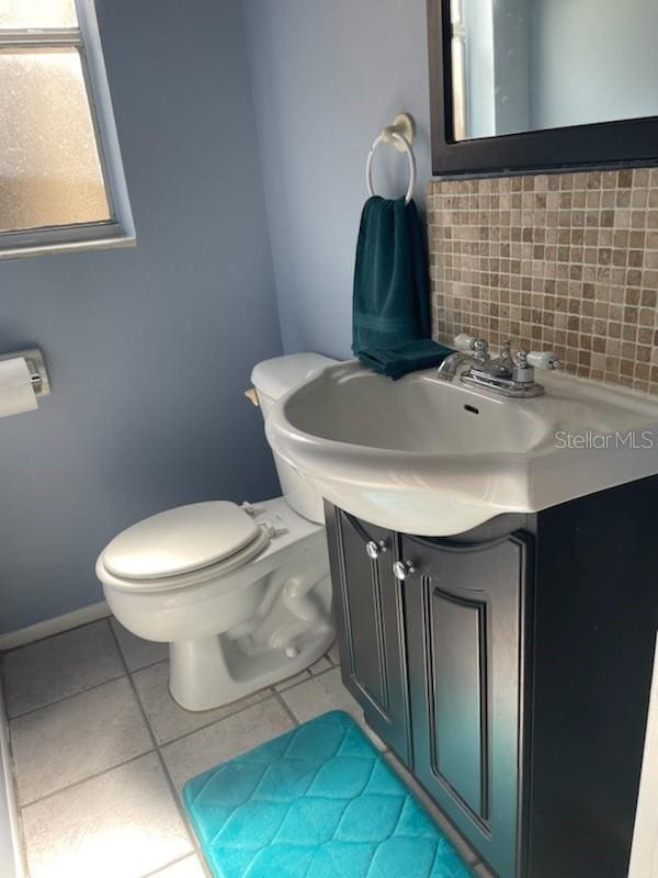 bathroom with tile patterned floors, vanity, toilet, and backsplash