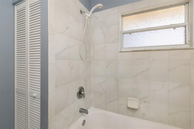 bathroom with tiled shower / bath combo and plenty of natural light