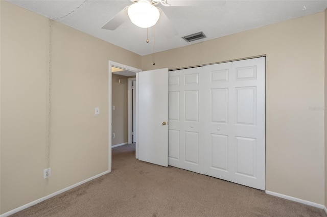 unfurnished bedroom featuring light carpet, a closet, and ceiling fan