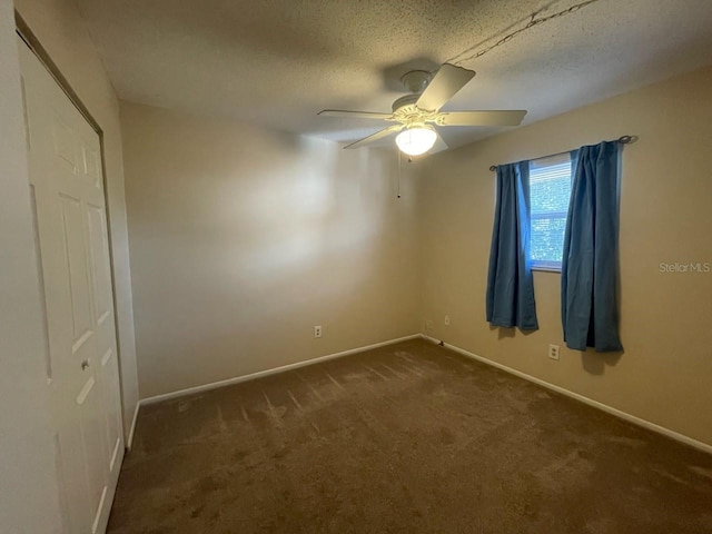 carpeted empty room with ceiling fan and a textured ceiling