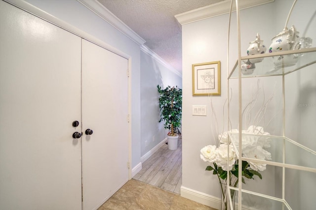 corridor with crown molding, a textured ceiling, and light tile flooring